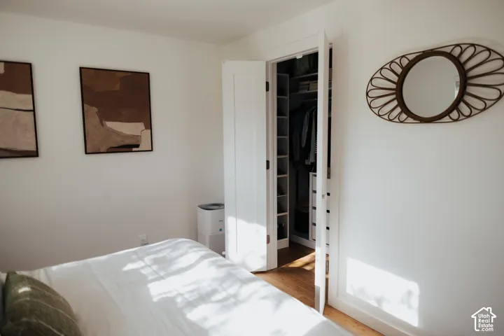 Interior space featuring wood-finish flooring and a closet with custom built-in shelving and drawer storage accessed via double-panel doors
