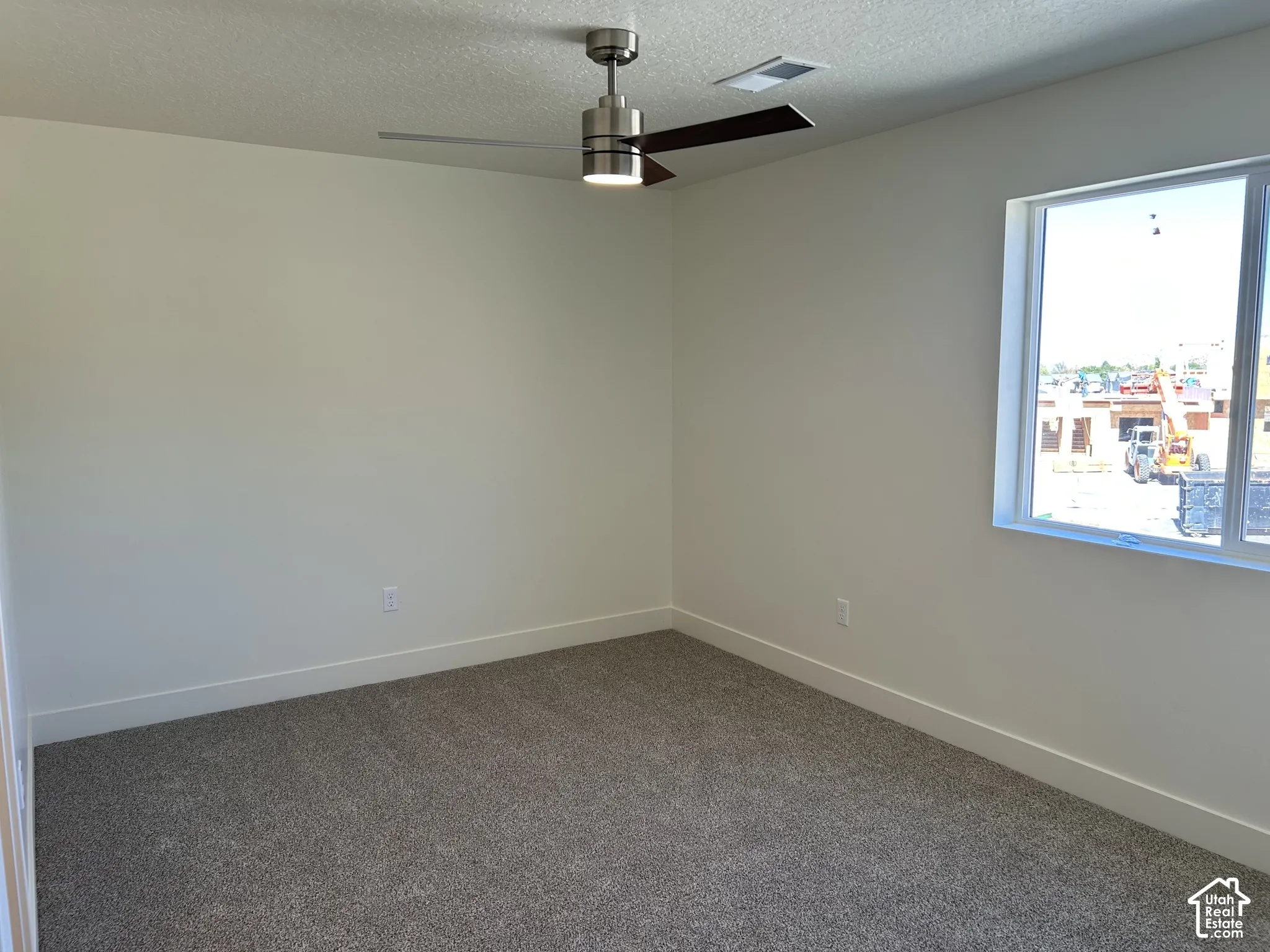 Integrated ceiling fan with light, recessed ceiling vent, neutral wall paint, window with white trim, and carpet flooring