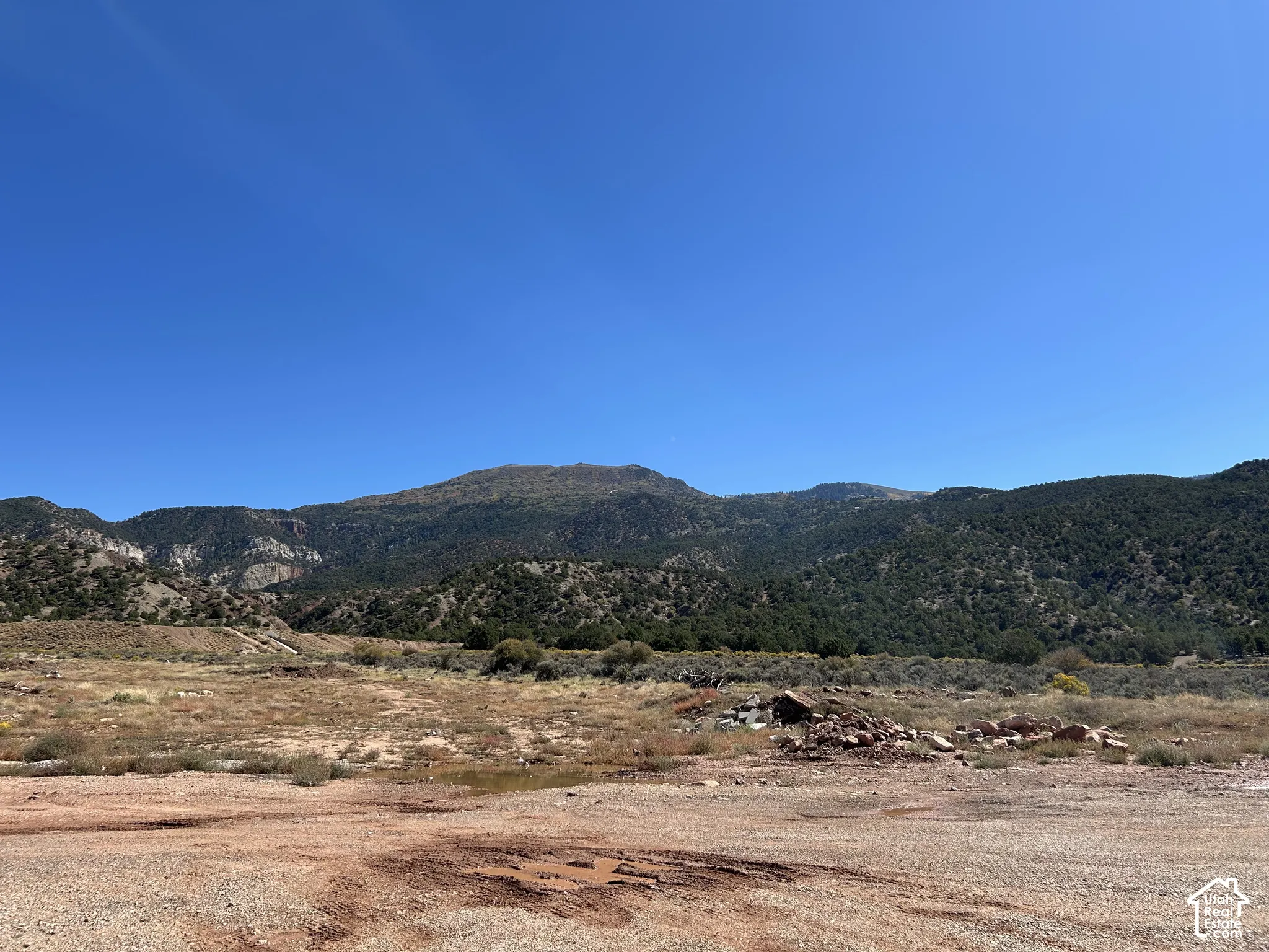 Expansive land parcel with clear skies, distant mountains, and varied terrain