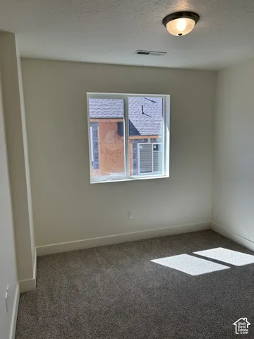 Recessed window with white trim, neutral-toned walls, and grey textured carpeting