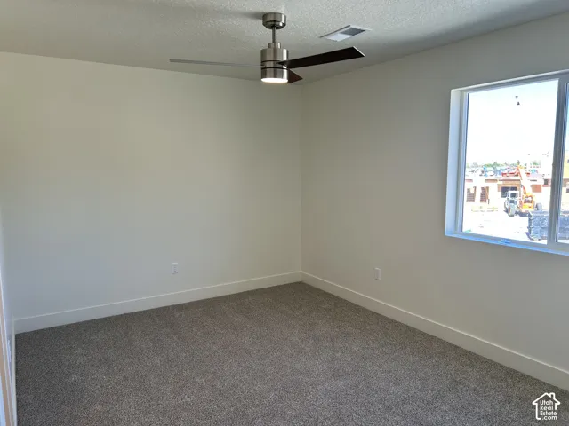 Integrated ceiling fan with light, recessed ceiling vent, neutral wall paint, window with white trim, and carpet flooring