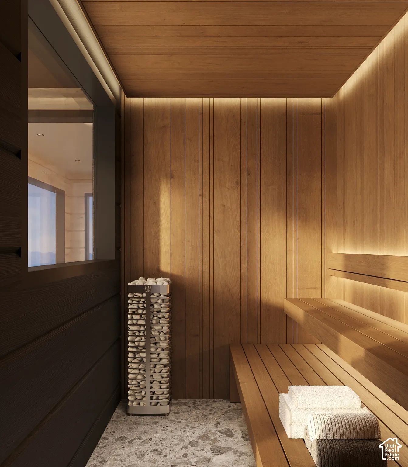 Wood-paneled sauna featuring tiered wooden benches, recessed lighting, and a stone-filled heating unit