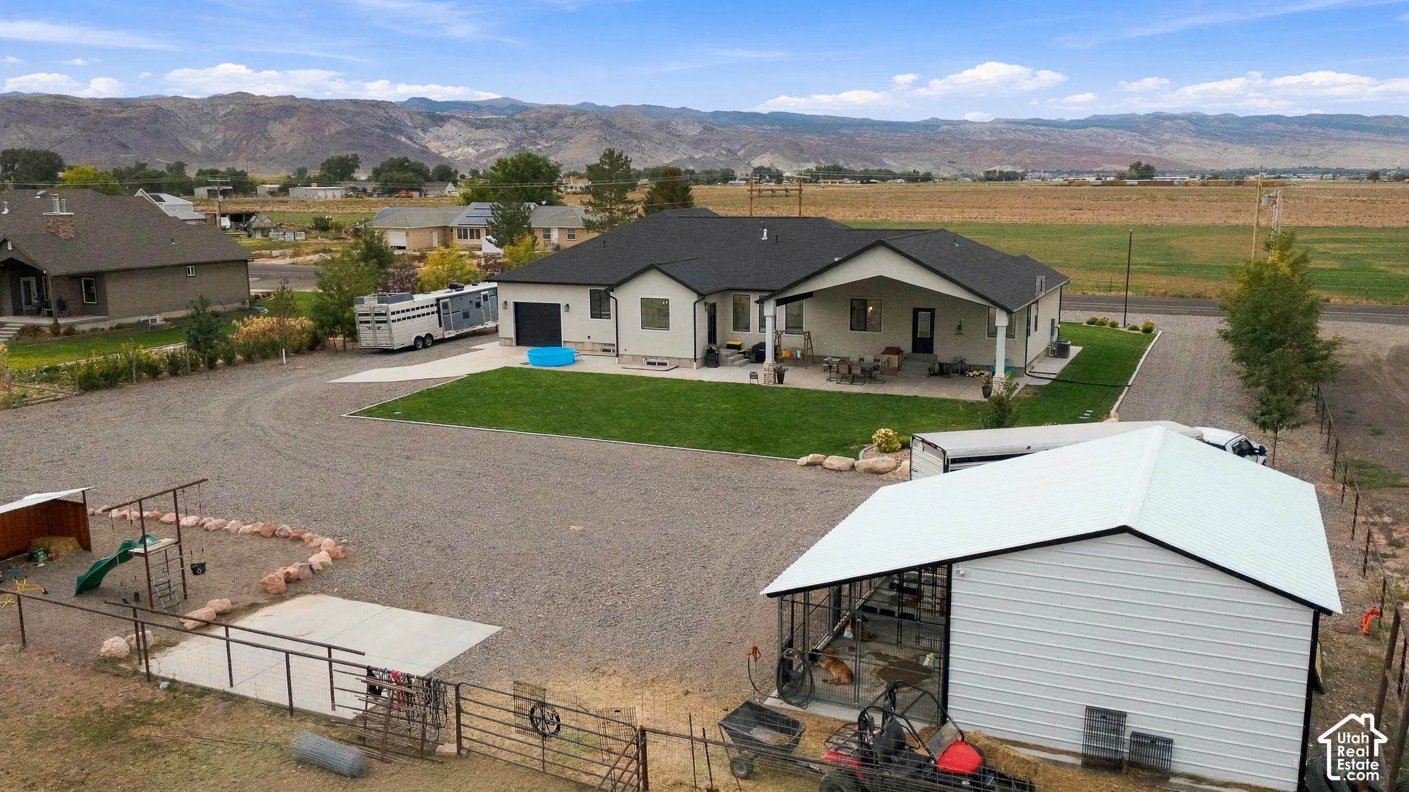 Single-story residence with a covered patio, attached garage, and a separate metal outbuilding
