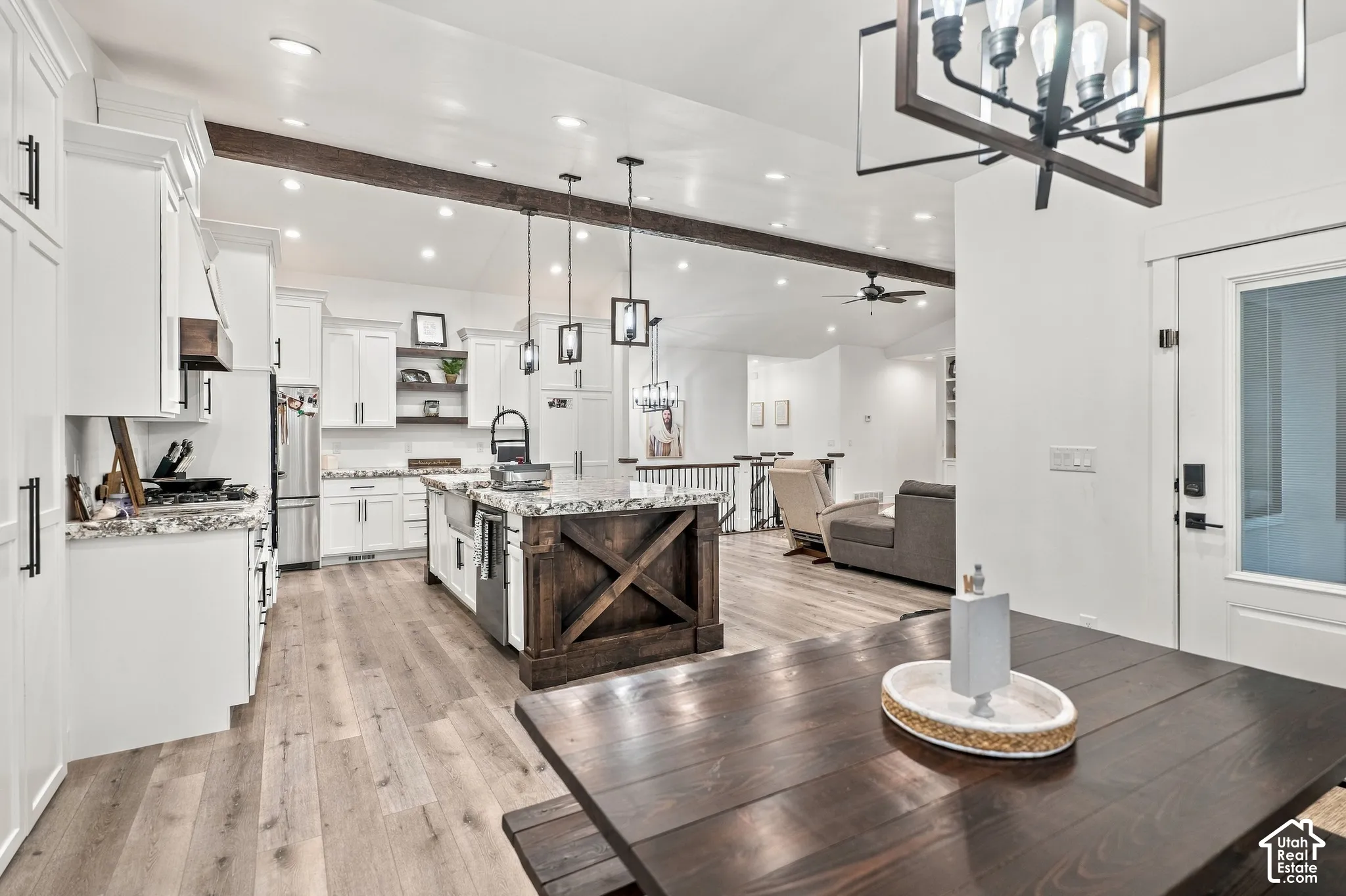 Kitchen featuring white cabinetry, wood-finish flooring, a wood-finish island with stone countertops, and stainless steel appliances