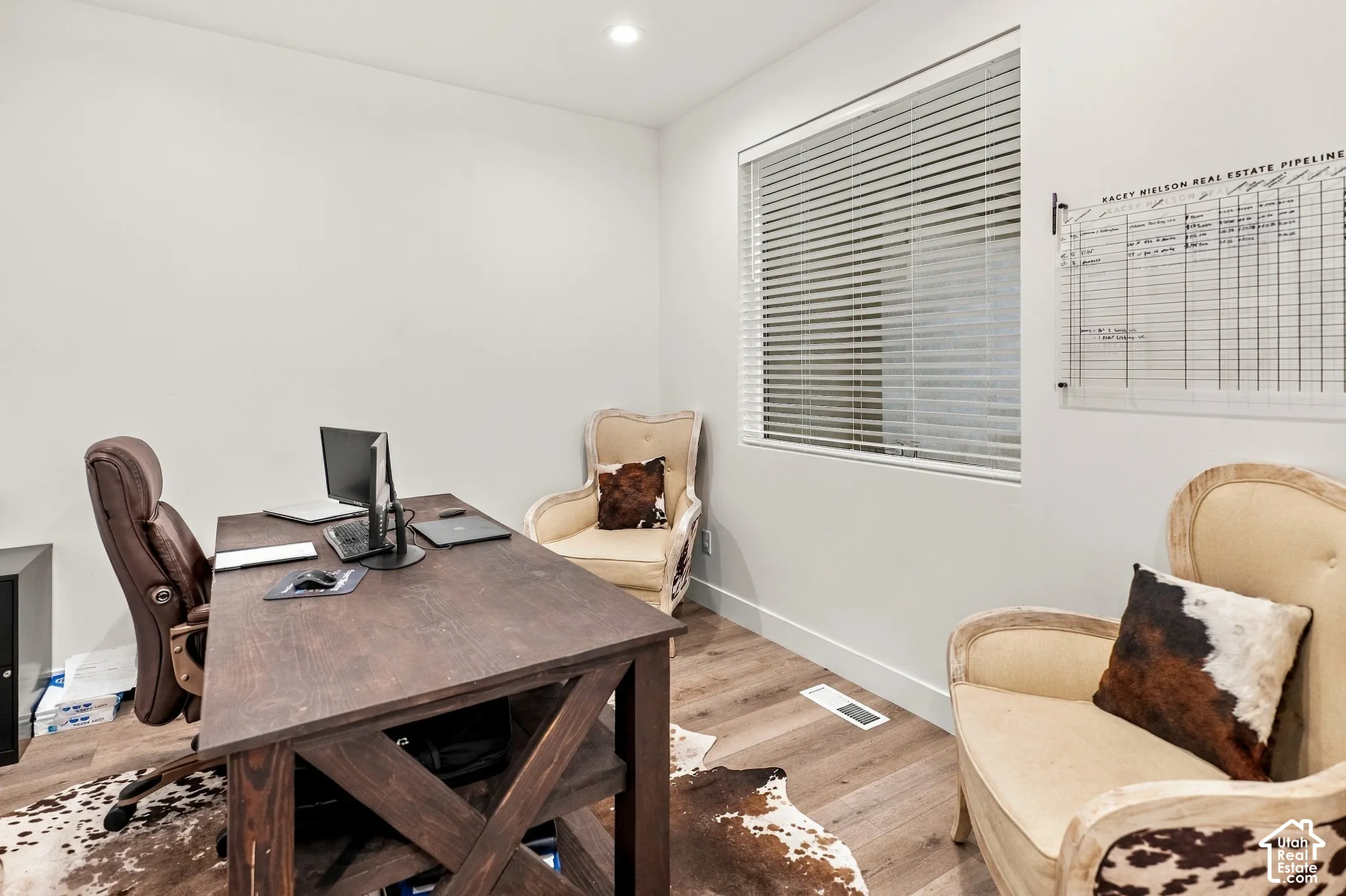 Recessed lighting, wood-finish flooring, white walls, large window with blinds, and white trim