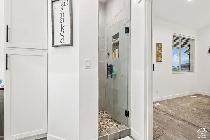 Glass-enclosed shower with tiled walls and river rock flooring