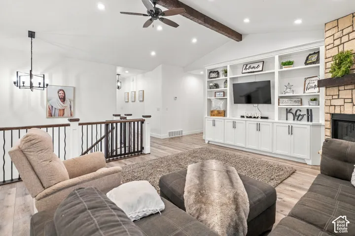 Vaulted ceiling featuring a dark wood beam and ceiling fan