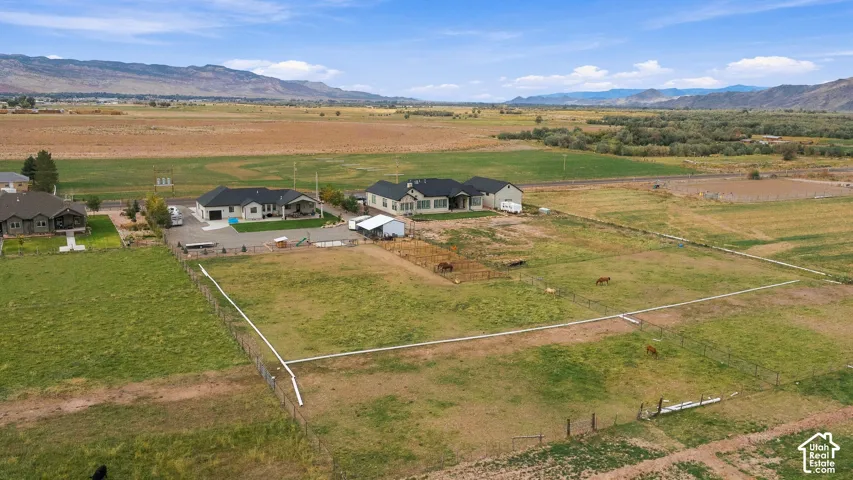 Extensive acreage featuring two residences, multiple fenced areas, and a detached outbuilding