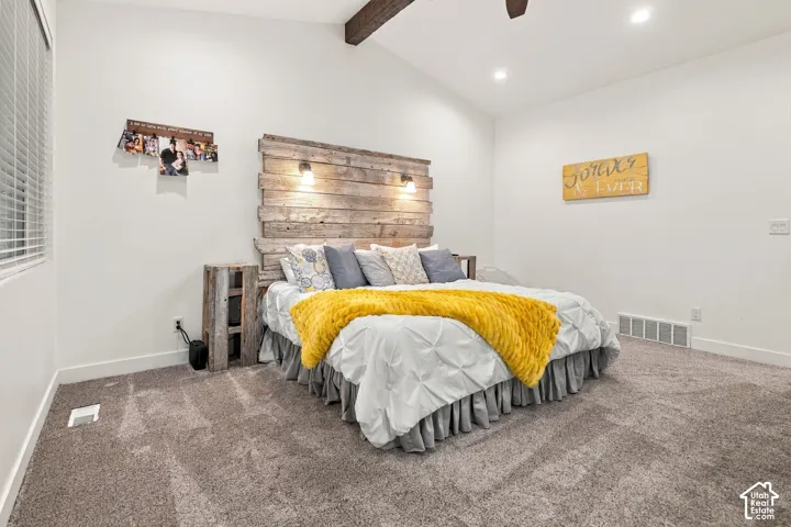Vaulted ceiling with exposed wood beam, recessed lighting, and a window with blinds