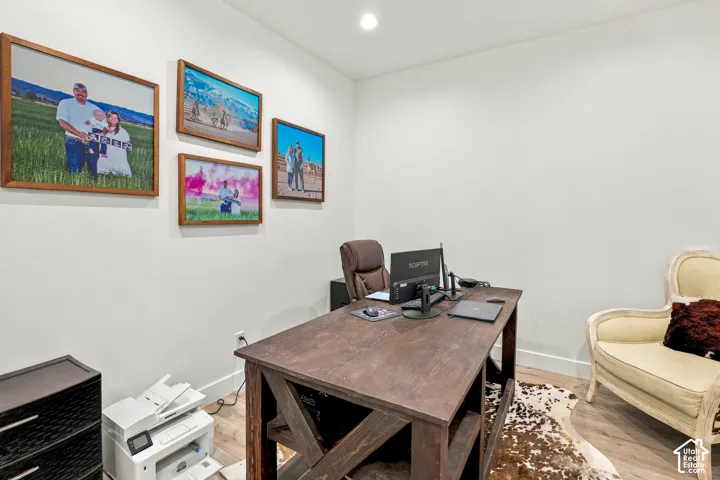 Recessed ceiling lighting, light wood-finish flooring, and white wall finishes