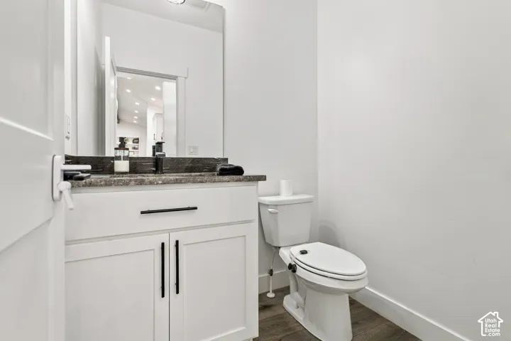 White vanity with dark stone-finish countertop, undermount sink, and black fixtures