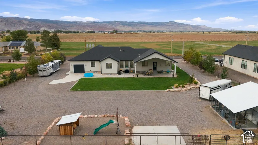 Single-story residence with a covered patio, attached garage, and gravel driveway