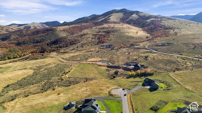 Expansive mountainous terrain with varied ground cover and residential structures