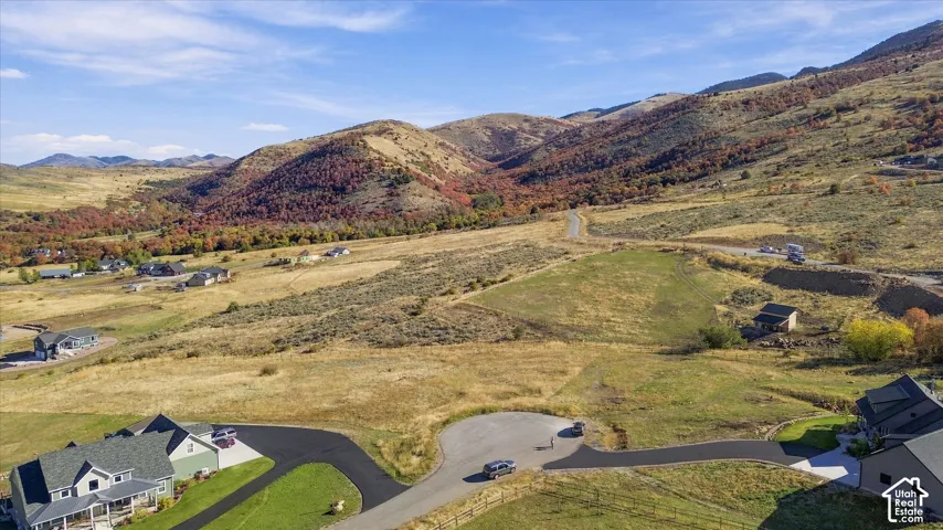 Expansive mountain landscape with diverse terrain and distant residential structures