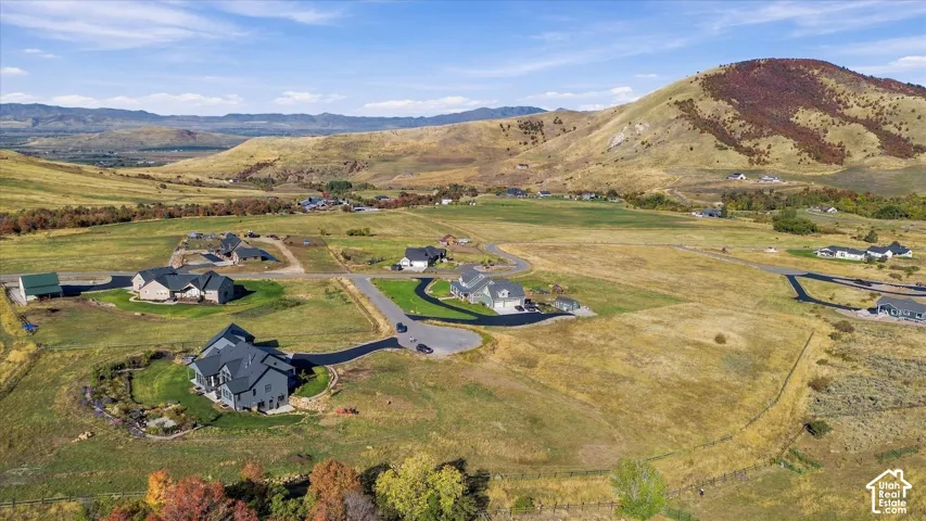 Expansive undeveloped land with distant mountain ranges and scattered residential properties