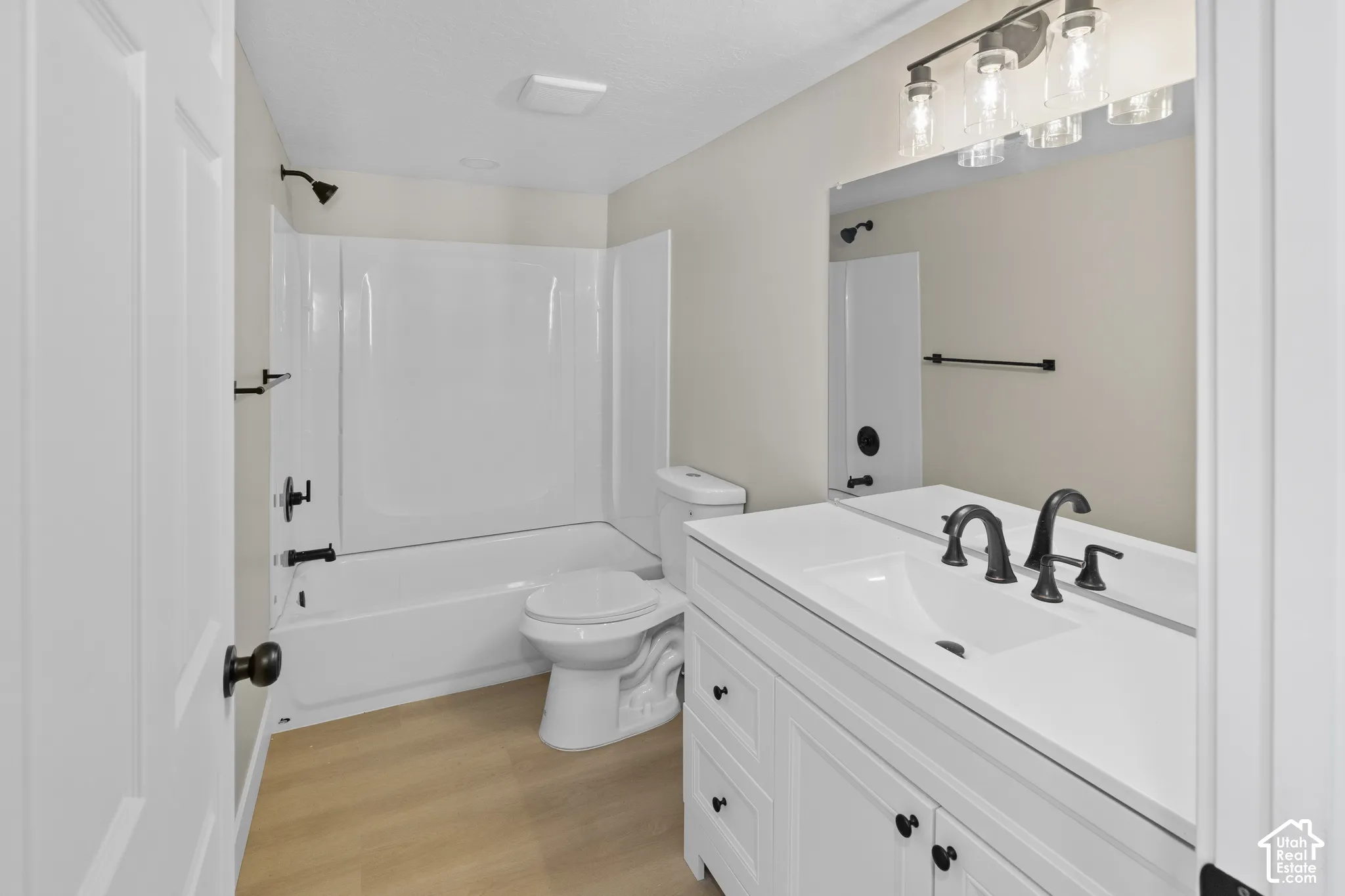 White vanity with integrated sink, sleek matte black hardware, and an expansive mirror