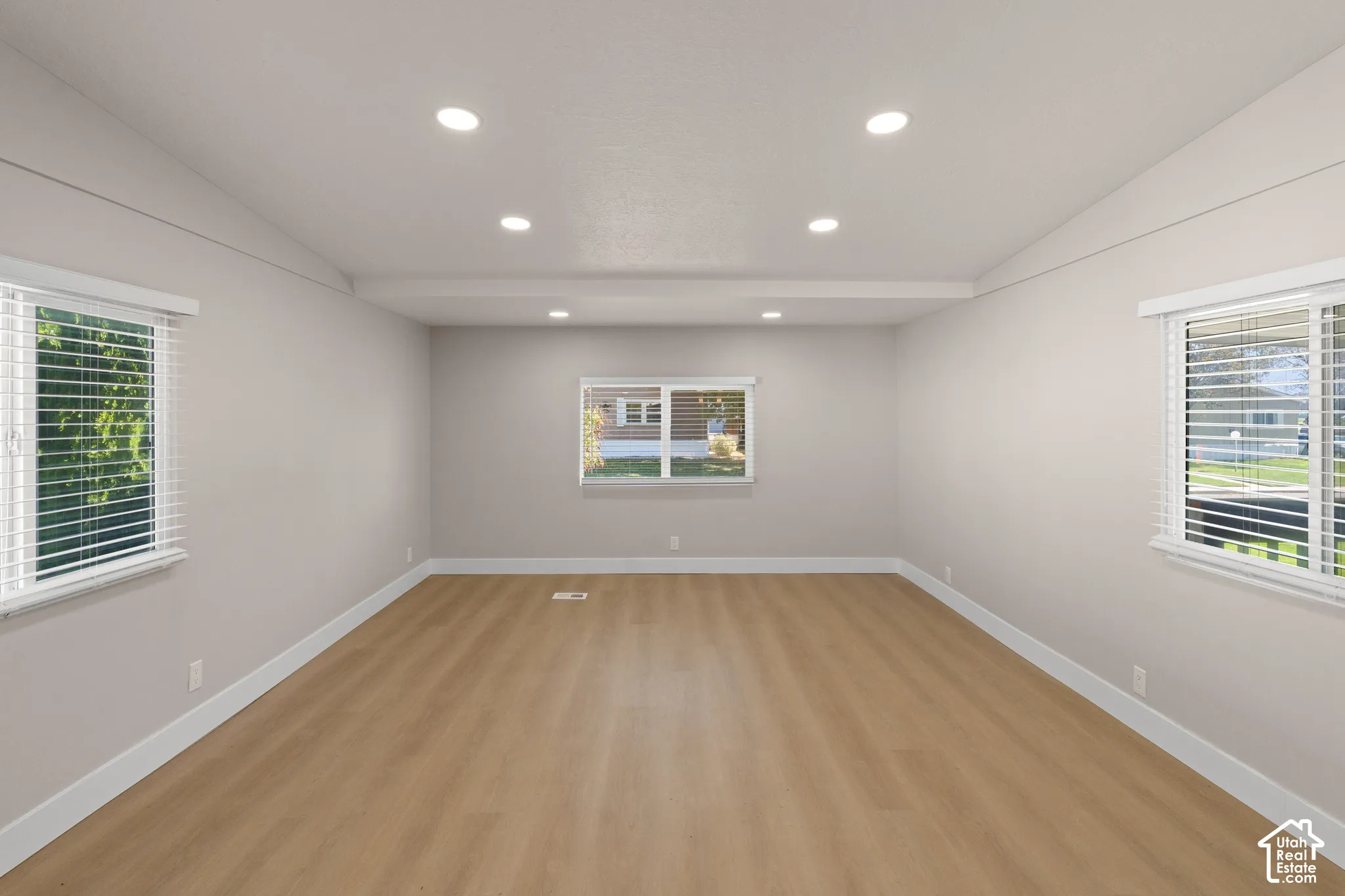 Recessed lighting, wood-finish flooring, multiple windows, and light gray walls
