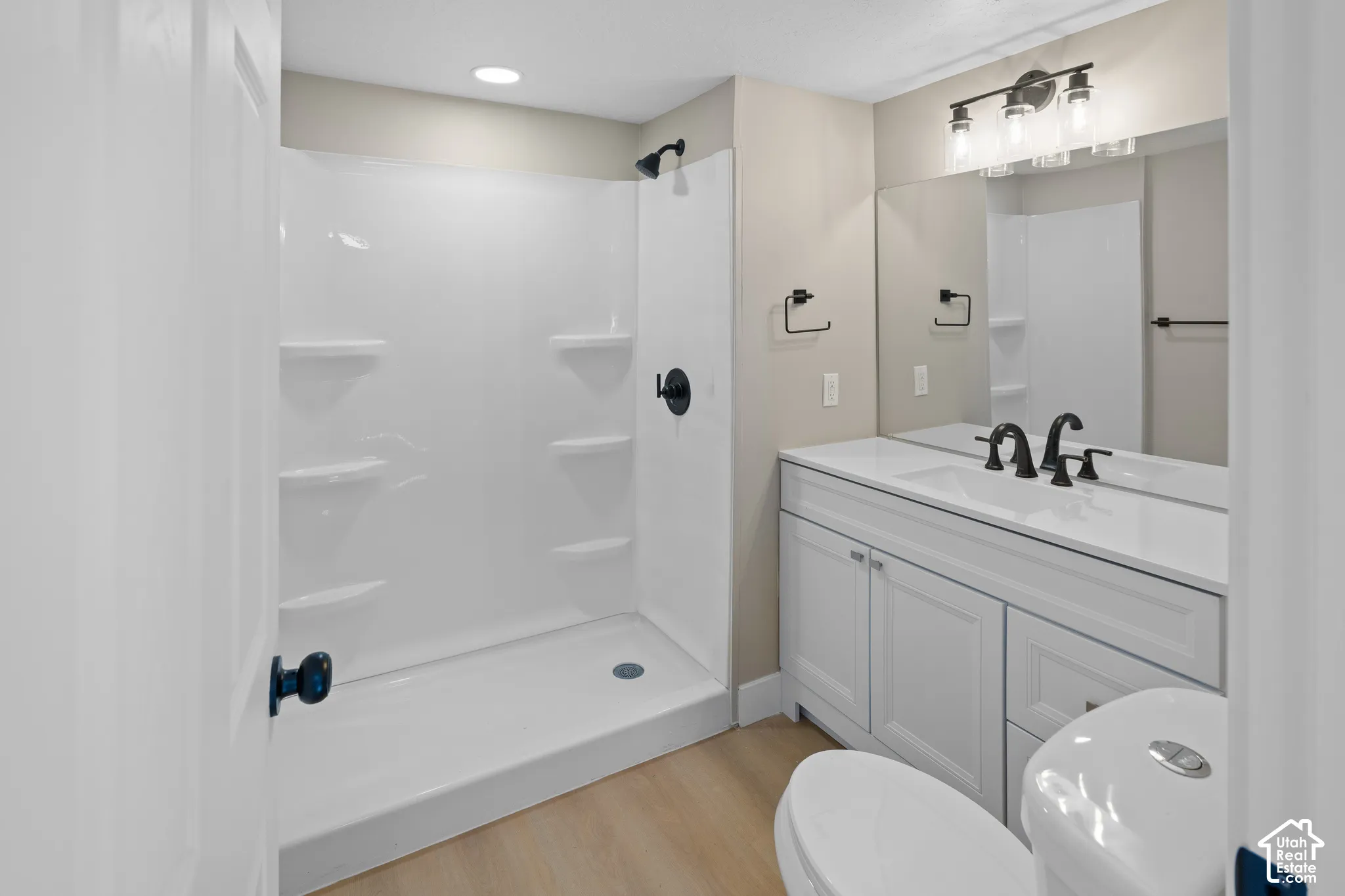 White vanity with a single basin sink, matte black faucet, and coordinating hardware