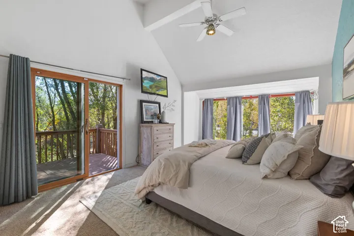 Vaulted ceiling with a ceiling fan, carpeted flooring, large sliding glass door, private exterior deck with wood railings, and a bay window