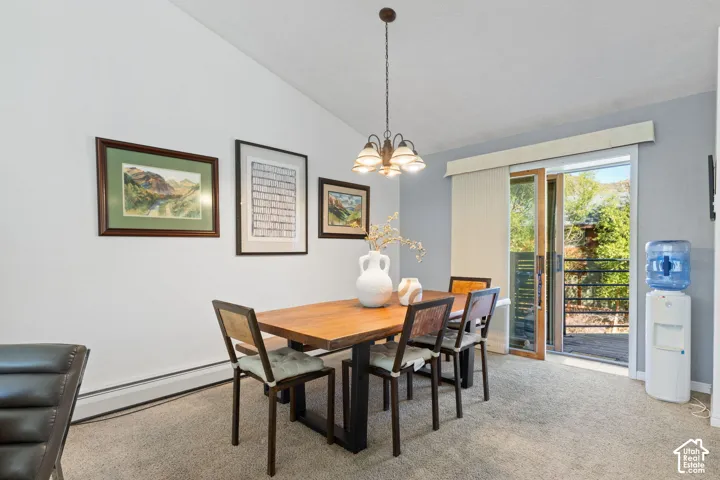Vaulted ceiling, pendant light fixture, sliding glass door, private exterior balcony, and carpet flooring
