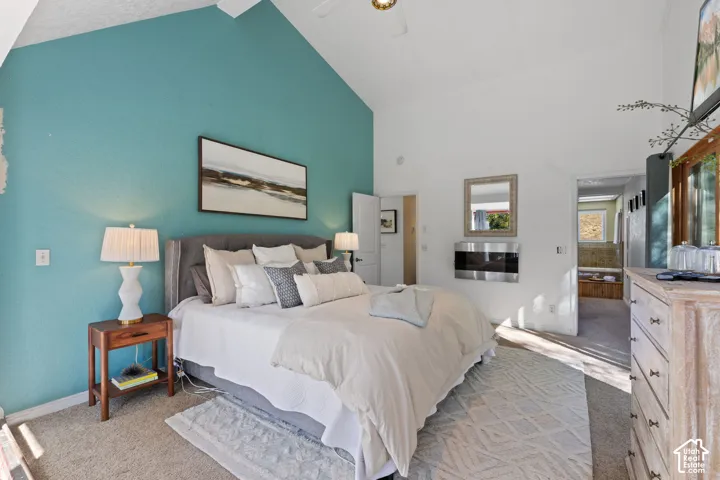 Vaulted ceiling, wall-mounted fireplace, and ceiling fan