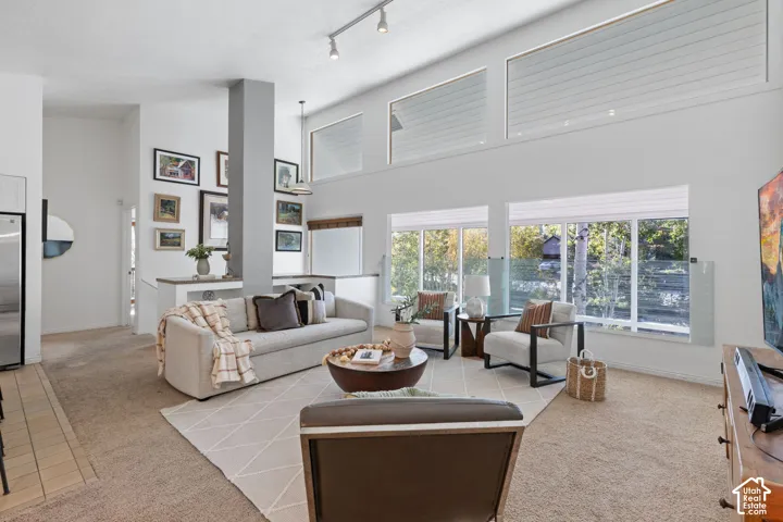 Vaulted ceilings with clerestory windows, large windows offering abundant natural light, track lighting, and a partial height wall