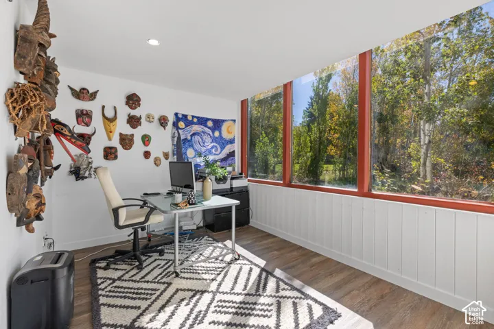 Floor-to-ceiling windows with red trim, wood-finish flooring, recessed lighting, and white paneled walls