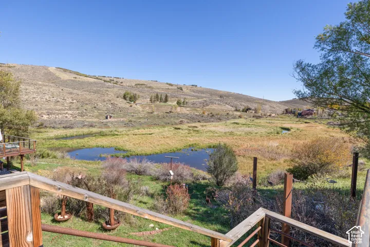 Expansive natural landscape featuring multiple ponds, surrounding grasslands, and distant hills
