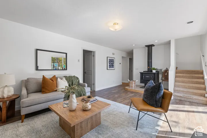 Wood-finish flooring throughout, a built-in wood-burning stove with a stone hearth, and a staircase with carpeted treads