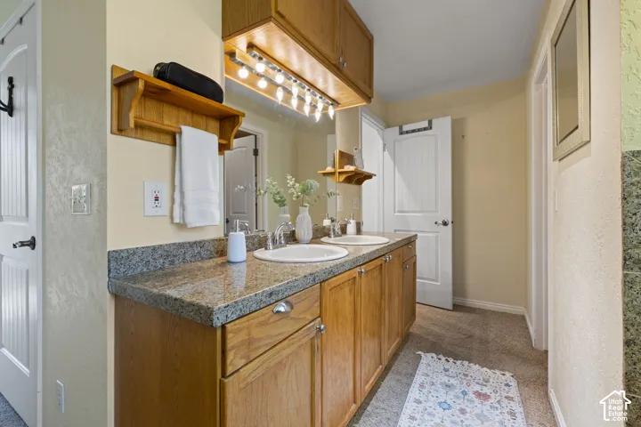 Double vanity with undermount sinks, granite-finish countertop, and wood-finish cabinetry