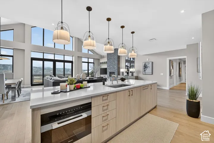 Spacious kitchen island with white countertop, integrated sink, and light wood-finish cabinetry