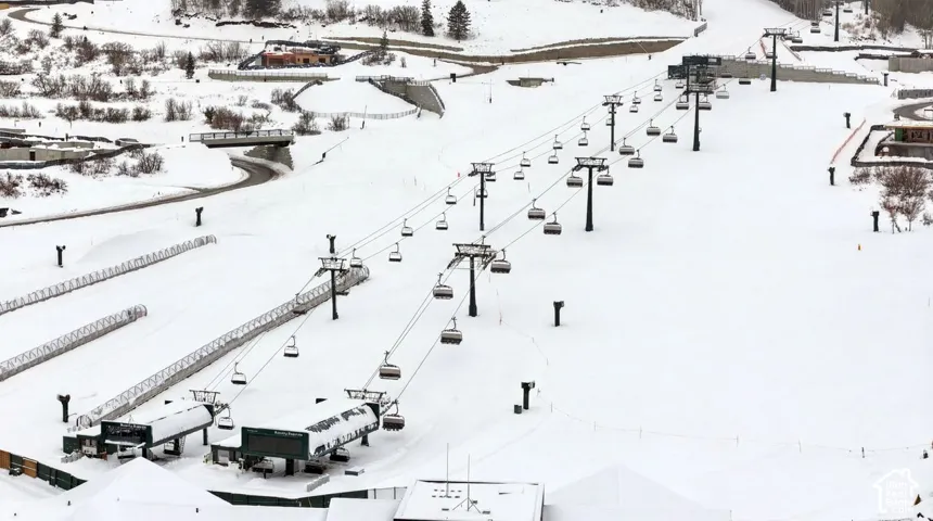 Snow-covered ski slope featuring multiple chairlifts and supporting structures