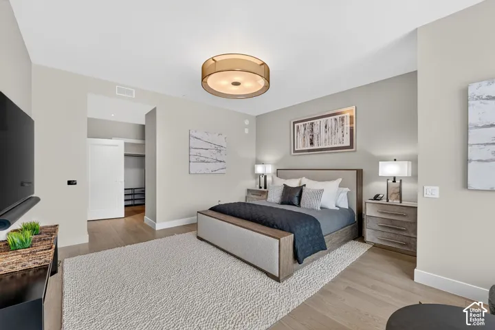 Recessed lighting, wood-finish flooring, and a contemporary ceiling fixture create a sophisticated ambiance