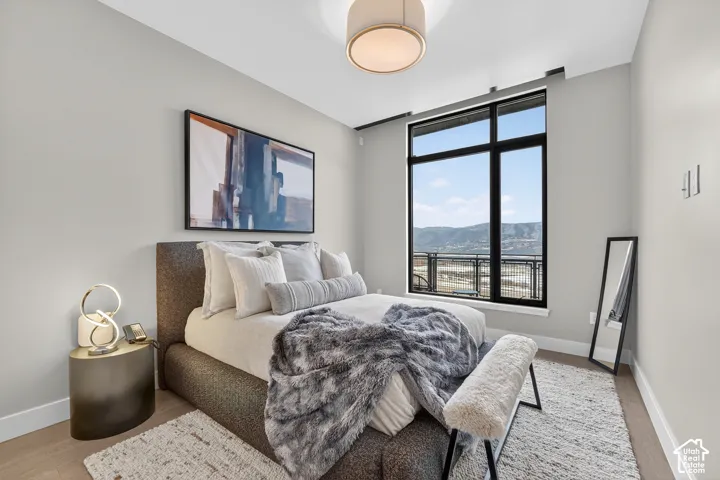 Expansive window with mountain scenery, recessed lighting, and wood-finish flooring