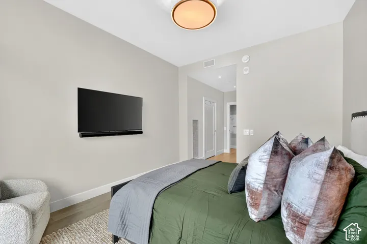 Light-toned walls, recessed lighting, and wood-finish flooring