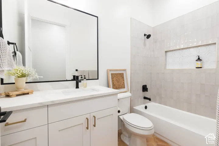 White vanity with gold-tone hardware, rectangular undermount sink, and black faucet