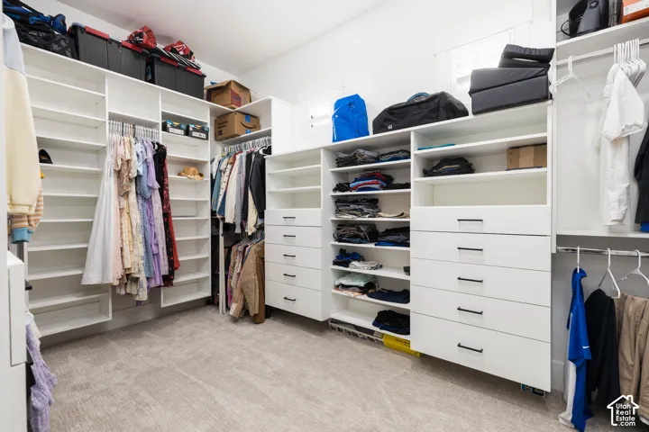 Custom closet system featuring white built-in shelving, integrated drawers with dark hardware, and multiple hanging rods