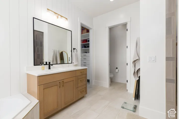 Wood-finish vanity with a white countertop and undermount sink