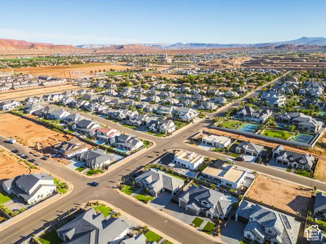 Aerial perspective highlighting a residential development with multiple single-family homes, paved streets, and undeveloped parcels