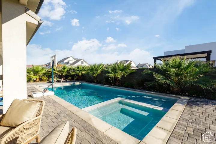 Pool with integrated spa and steps, surrounded by paver patio