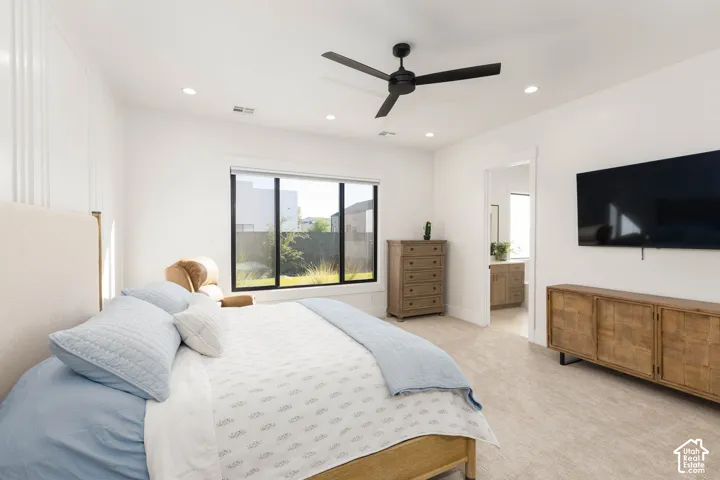 Recessed lighting, ceiling fan, large window, wall-mounted television, and wood-finish cabinetry