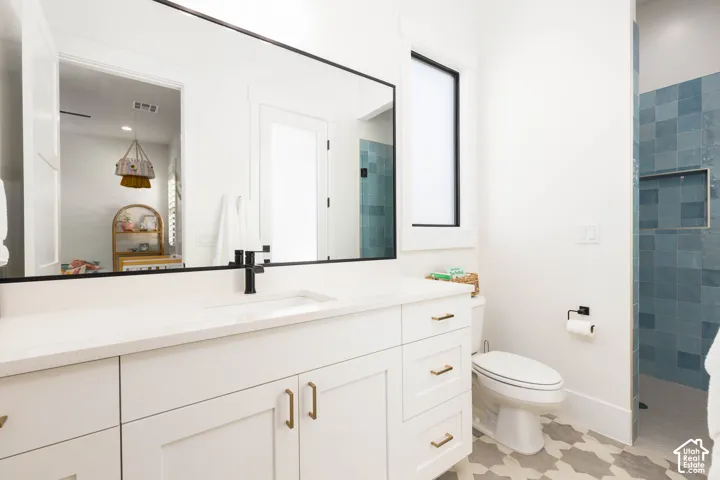 White vanity with gold-tone hardware, a rectangular undermount sink, and a black single-lever faucet