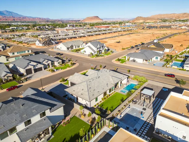 Aerial view of a residential neighborhood featuring modern homes, paved streets, and mountainous desert scenery