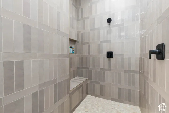 Tiled shower with a built-in bench, integrated niche, and matte black fixtures