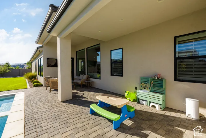 Covered patio with recessed lighting, paver flooring, and black-framed windows