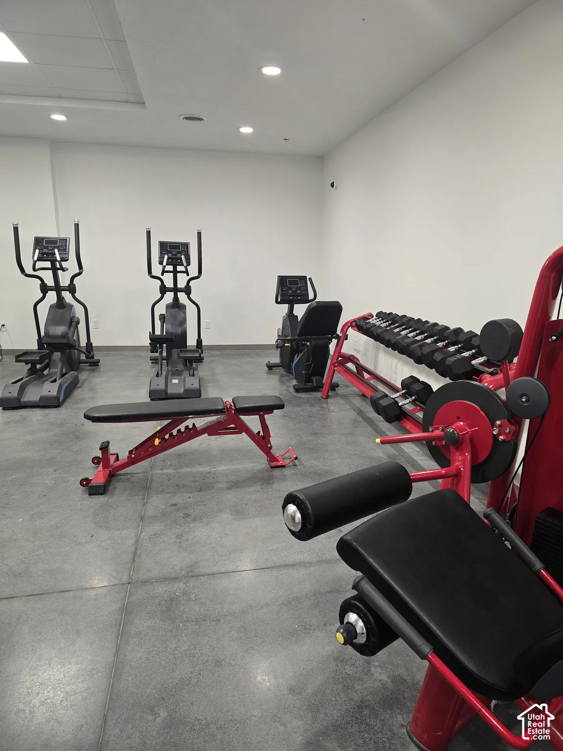 Fitness center with concrete flooring, recessed lighting, and white walls