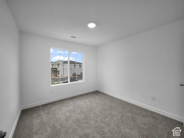 Neutral wall tones, recessed ceiling lighting, and plush carpeting create a versatile interior
