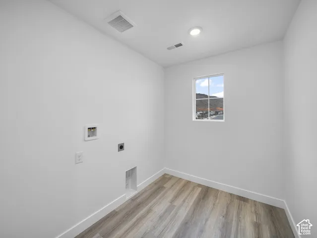 Wood-finish flooring, recessed lighting, white walls, and a window with mountain scenery