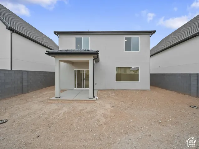 Rear exterior featuring a covered patio, sliding glass door access, stucco finish, and multiple windows