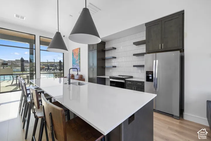 Expansive kitchen island with a white countertop and integrated sink, complemented by built-in dark cabinetry and open shelving